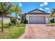 Single-story home with gray garage door and brick driveway at 17649 Northwood Pl, Bradenton, FL 34202