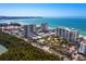 Aerial view of beachfront condo building with tennis courts and ocean views at 1800 Benjamin Franklin Dr # B408, Sarasota, FL 34236