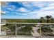 Spacious balcony with glass railings and lush greenery views at 1800 Benjamin Franklin Dr # B408, Sarasota, FL 34236