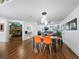 Bright dining room with wooden table and orange chairs, adjacent to a library at 1800 Benjamin Franklin Dr # B408, Sarasota, FL 34236