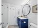 Modern bathroom featuring navy blue vanity, shiplap walls, and a glass-enclosed shower at 1864 Clematis St, Sarasota, FL 34239