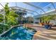 Beautiful enclosed pool and spa surrounded by lush tropical plants and clear blue water at 1864 Clematis St, Sarasota, FL 34239