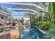 Screened in pool and spa with patio area, tropical plants, and lounge chairs at 1864 Clematis St, Sarasota, FL 34239