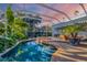 Stunning enclosed pool area with a spa, lush plants, and serene atmosphere at sunset at 1864 Clematis St, Sarasota, FL 34239