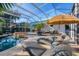 Enclosed pool area with hot tub, outdoor seating, sunshade, and lush landscaping provides a private retreat at 1864 Clematis St, Sarasota, FL 34239