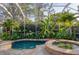 Gorgeous pool and hot tub with a screened enclosure and tropical landscaping for a private oasis at 1864 Clematis St, Sarasota, FL 34239