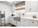 Modern kitchen with white cabinets, floating shelves, and a concrete farmhouse sink at 1990 Main St # 6, Sarasota, FL 34236