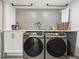 Laundry room with Samsung washer and dryer, and patterned tile at 1990 Main St # 6, Sarasota, FL 34236