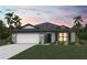 One-story home with gray exterior, white garage door, and landscaping at 21192 Winside Ave, Port Charlotte, FL 33952