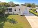 Aerial view of a yellow house with a driveway and lush green lawn at 2711 Larkspur Dr, Punta Gorda, FL 33950