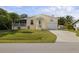 Cute yellow house with a screened porch, palm trees, and a spacious driveway at 2711 Larkspur Dr, Punta Gorda, FL 33950