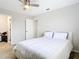 Bedroom featuring hardwood floors, neutral walls and a comfortable white bed, illuminated by a ceiling fan at 31 Bunker Pl, Rotonda West, FL 33947