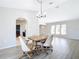 Bright dining area features a wooden table with beige chairs, luxury vinyl plank flooring, and modern lighting fixture at 31 Bunker Pl, Rotonda West, FL 33947