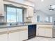 Bright kitchen featuring light cabinets, gray counters and black appliances with a view into the living room at 31 Bunker Pl, Rotonda West, FL 33947