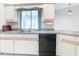 Kitchen featuring white cabinets and dark appliances, complemented by light countertops and a window view at 31 Bunker Pl, Rotonda West, FL 33947