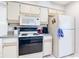 Bright kitchen with white cabinets and appliances, featuring tile floors and neutral-toned walls at 31 Bunker Pl, Rotonda West, FL 33947