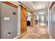 Long hallway with gray walls and barn doors leading to other rooms at 3218 Big Sky Way, Bradenton, FL 34211