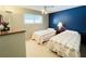 Bedroom with two twin beds, nightstand, and blue accent wall at 3230 Banyan Ter, Sarasota, FL 34237