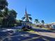 Gated entrance to a community with palm trees and American flag at 3230 Banyan Ter, Sarasota, FL 34237