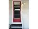 Red front door with screen door and small steps at 3230 Banyan Ter, Sarasota, FL 34237