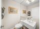 Small bathroom with a white sink, toilet, and framed artwork at 3331 Old Oak Dr, Sarasota, FL 34239