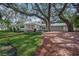 White single story home with brick driveway, lush landscaping, and large shade trees at 3331 Old Oak Dr, Sarasota, FL 34239