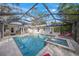 Relaxing pool and spa with screened enclosure, outdoor kitchen, and lounge chairs at 3331 Old Oak Dr, Sarasota, FL 34239