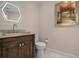 Stylish powder room with hexagon mirror and art at 3491 Byron Ln, Longboat Key, FL 34228