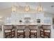 Modern kitchen featuring white cabinets, a large island, and stylish light fixtures at 3491 Byron Ln, Longboat Key, FL 34228