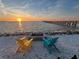 Relaxing sunset view by the beach with colorful chairs, and a pier in the background at 423 Bahia Beach Blvd, Ruskin, FL 33570