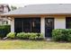 The exterior of the home shows a sliding glass door, entry door, and tidy green foliage at 4629 Kingsmere # 20, Sarasota, FL 34235