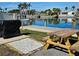 Waterfront backyard with a grill, picnic table, and dock on a sunny day at 4900 38Th S Way # 201, St Petersburg, FL 33711