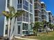 Beautiful condominium building featuring screened-in lanais and lush landscaping with mature palm trees at 4900 38Th S Way # 201, St Petersburg, FL 33711