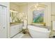 Elegant bathroom with a freestanding soaking tub, double vanity, and large mirror at 5118 Chateau Ct, Sarasota, FL 34238