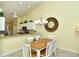 Dining area with wood table and white chairs, adjacent to kitchen at 5250 Hyland Hills Ave # 1525, Sarasota, FL 34241