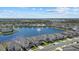 Aerial view of a lakefront community with numerous houses and a fountain at 5307 Grove Mill Loop, Lakewood Ranch, FL 34211