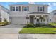 Two-story house with gray siding, two-car garage, and landscaped yard at 5307 Grove Mill Loop, Lakewood Ranch, FL 34211