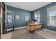 Spacious home office with teal walls, a large desk, and hexagon patterned rug at 5307 Grove Mill Loop, Lakewood Ranch, FL 34211