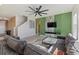 Living Room with sectional sofa, large windows, and a green accent wall at 5307 Grove Mill Loop, Lakewood Ranch, FL 34211