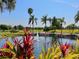 Community features a pond with fountain, lush landscaping, and palm trees at 5449 Chanteclaire # 75, Sarasota, FL 34235