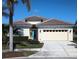 One-story house with tile roof, two-car garage, and landscaped yard at 5452 Club View Ln, North Port, FL 34287