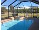 Inviting screened pool and spa with brick coping and a tranquil water feature at 5452 Club View Ln, North Port, FL 34287