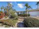 Landscaped front yard with tropical plants and a driveway at 550 De Narvaez Dr, Longboat Key, FL 34228