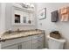 Bathroom featuring a vanity with granite countertop, framed mirror, and neutral decor at 5616 Mashie Cir, North Port, FL 34287