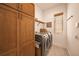 Laundry room with wooden cabinets, washer, dryer, and shelving at 6039 Salt Grass St, Bradenton, FL 34210