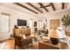 Spacious living room featuring hardwood floors, wood beams, and a neutral color palette at 6039 Salt Grass St, Bradenton, FL 34210