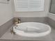 Oval soaking tub with gray tile surround in Primary bathroom at 649 Maraviya Blvd, Nokomis, FL 34275