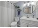 Updated bathroom with white vanity and round mirror at 6507 36Th Avenue W Dr, Bradenton, FL 34209