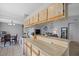 Modern kitchen with light wood cabinets and black countertops at 6507 36Th Avenue W Dr, Bradenton, FL 34209