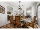 Formal dining room features a rich wood table, glass-top, and elegant chandelier at 6841 74Th Street E Cir, Bradenton, FL 34203